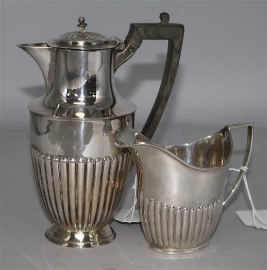 A late Victorian silver cream jug and an Edwardian silver hot water pot.